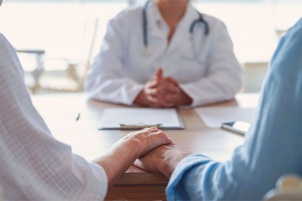 Couple holding hands in doctors office.